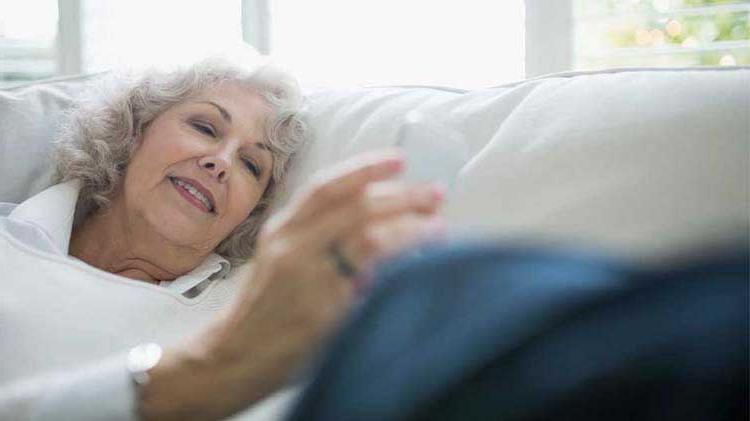 Senior woman looking at her portable device checking her mobile health monitoring app.