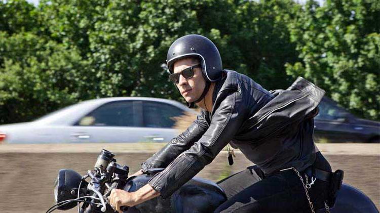 Man with a helmet riding a motorcycle.