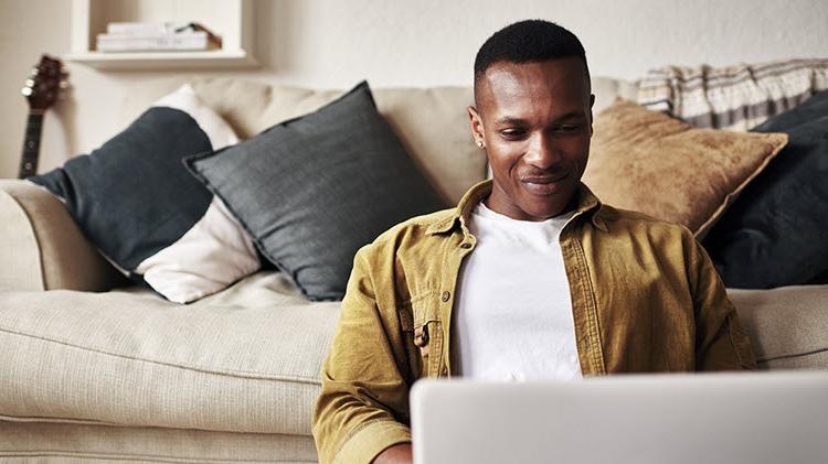 Man working on his laptop researching how to buy a car online.