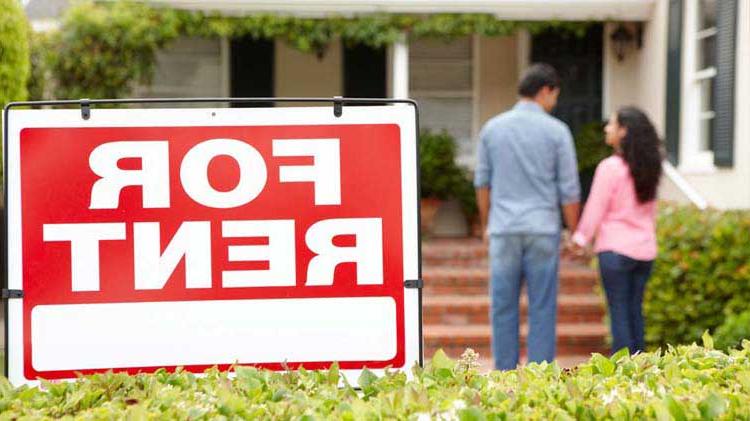 Red and white "FOR RENT" sign in front of house with a couple holding hands in the background.