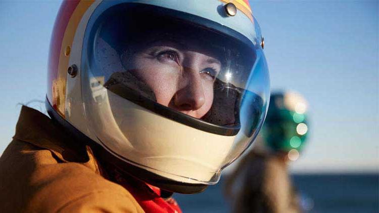 Person practicing motorcycle safety by wearing a helmet.