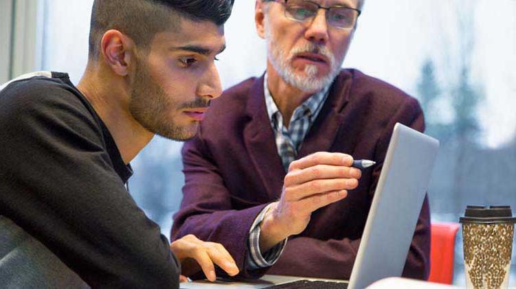 Two men searching for a job on a computer.